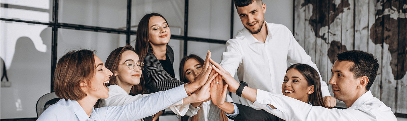 A diverse group of business professionals joyfully high-fiving each other in a celebratory moment.